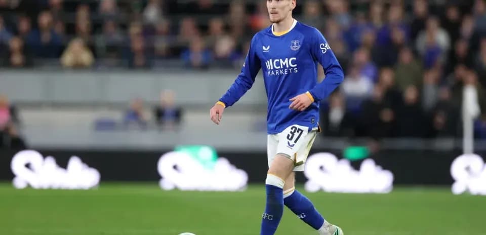 Player in blue kit walking on football pitch