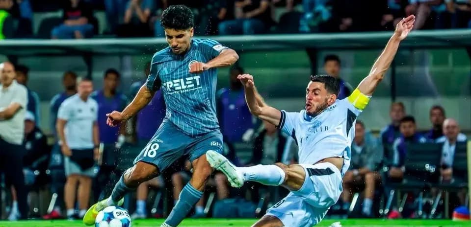 Player tackling opponent during UEFA match