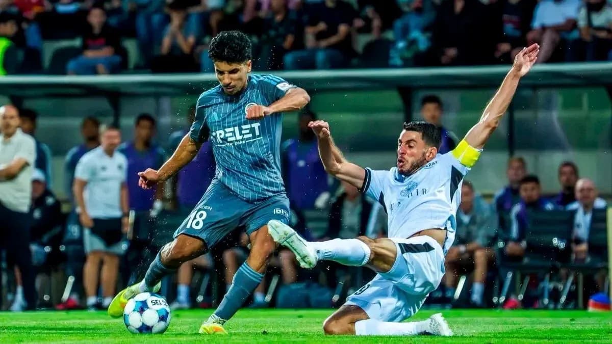 Player tackling opponent during UEFA match