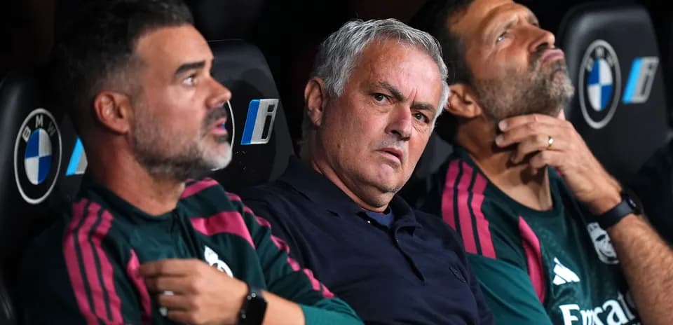 Coaching staff seated on the bench during match