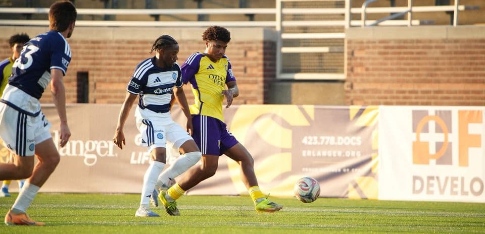 Two players competing for the ball in football match