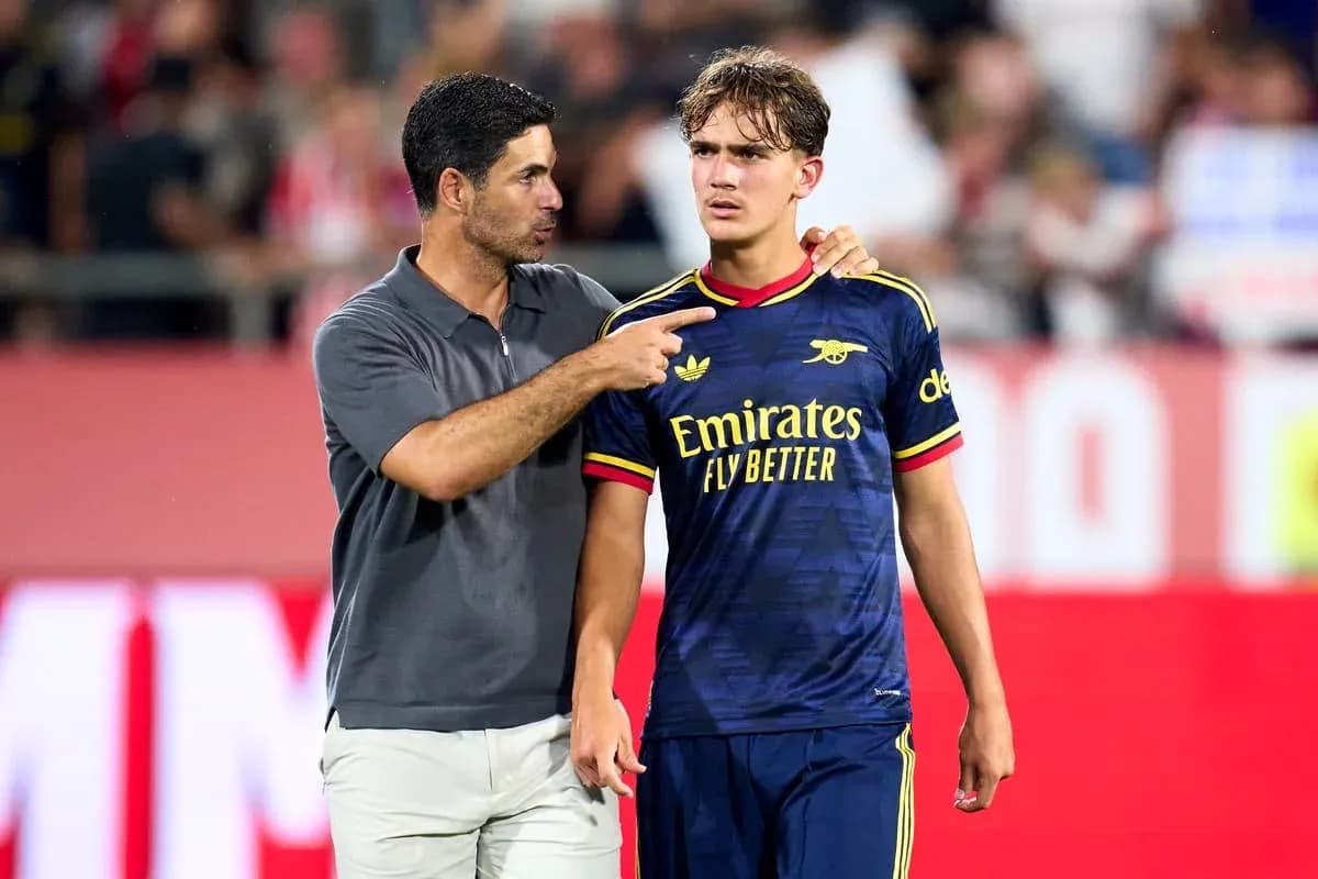 Coach speaking to player on the pitch