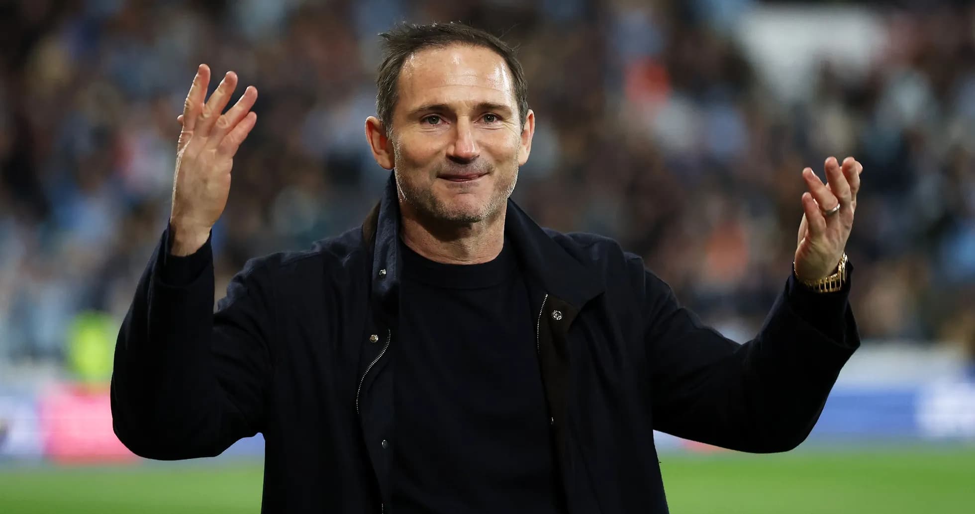 Coach gesturing to fans during match celebration