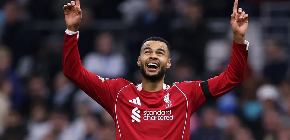 Player celebrating with raised arms in Liverpool kit