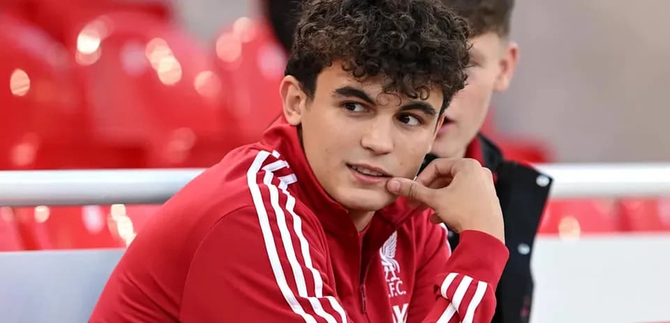 Player in Liverpool kit sitting on bench