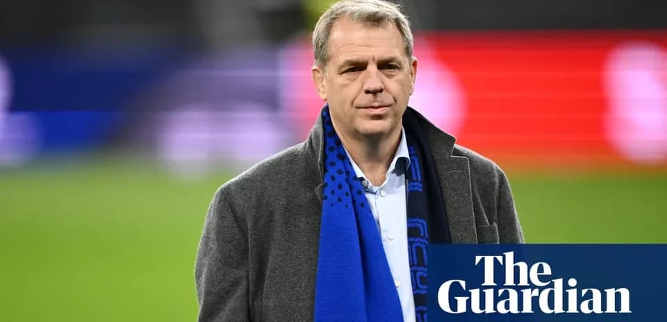 Man in coat with scarf at sports venue