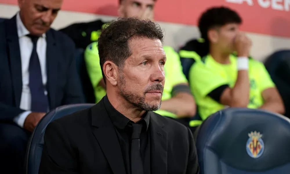 Coach seated on bench during match at stadium