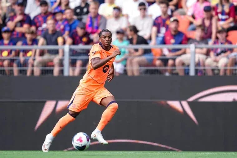 Player in orange kit sprinting on the field