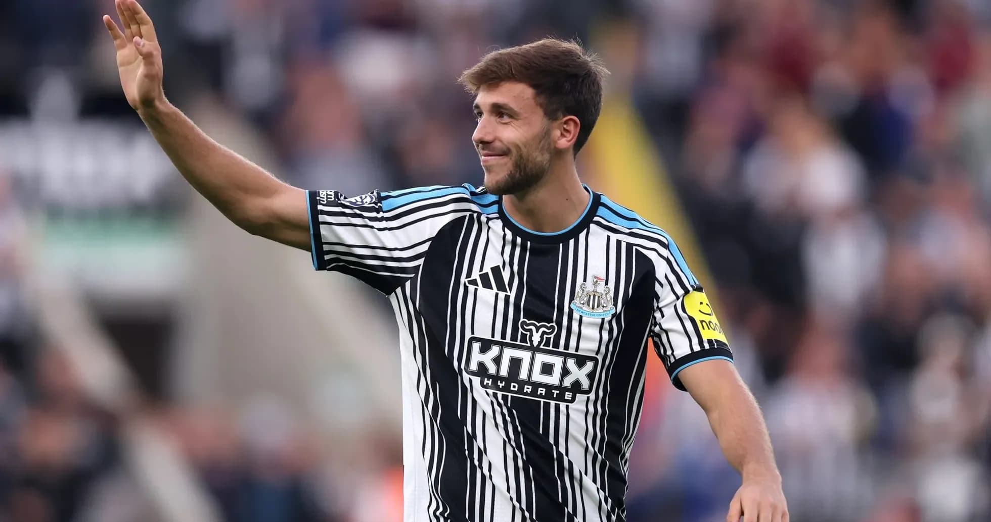 Player waving to fans during match at St James' Park
