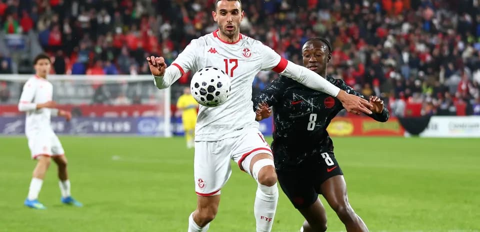 Tunisian player controlling ball while being challenged