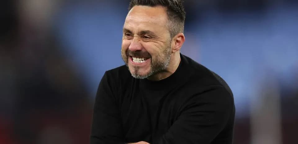 Coach celebrating with a big smile on pitch