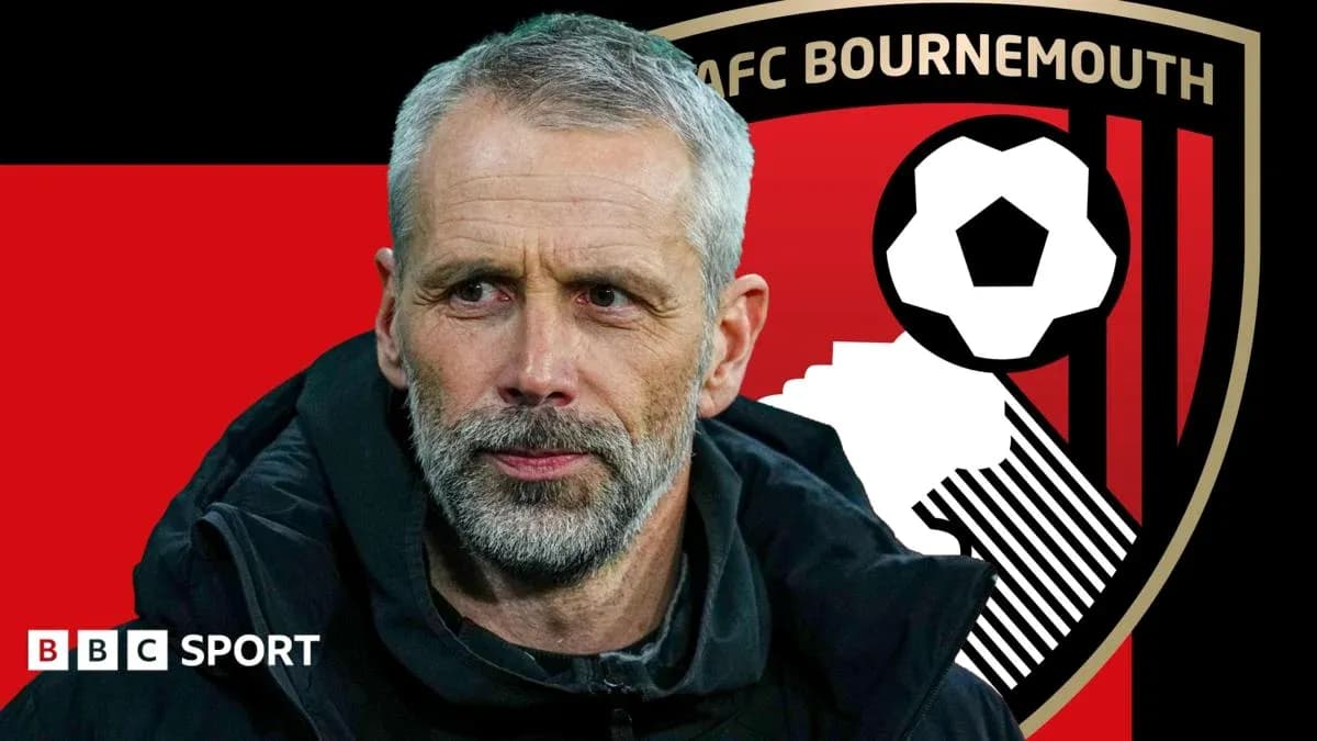 AFC Bournemouth manager in front of club logo