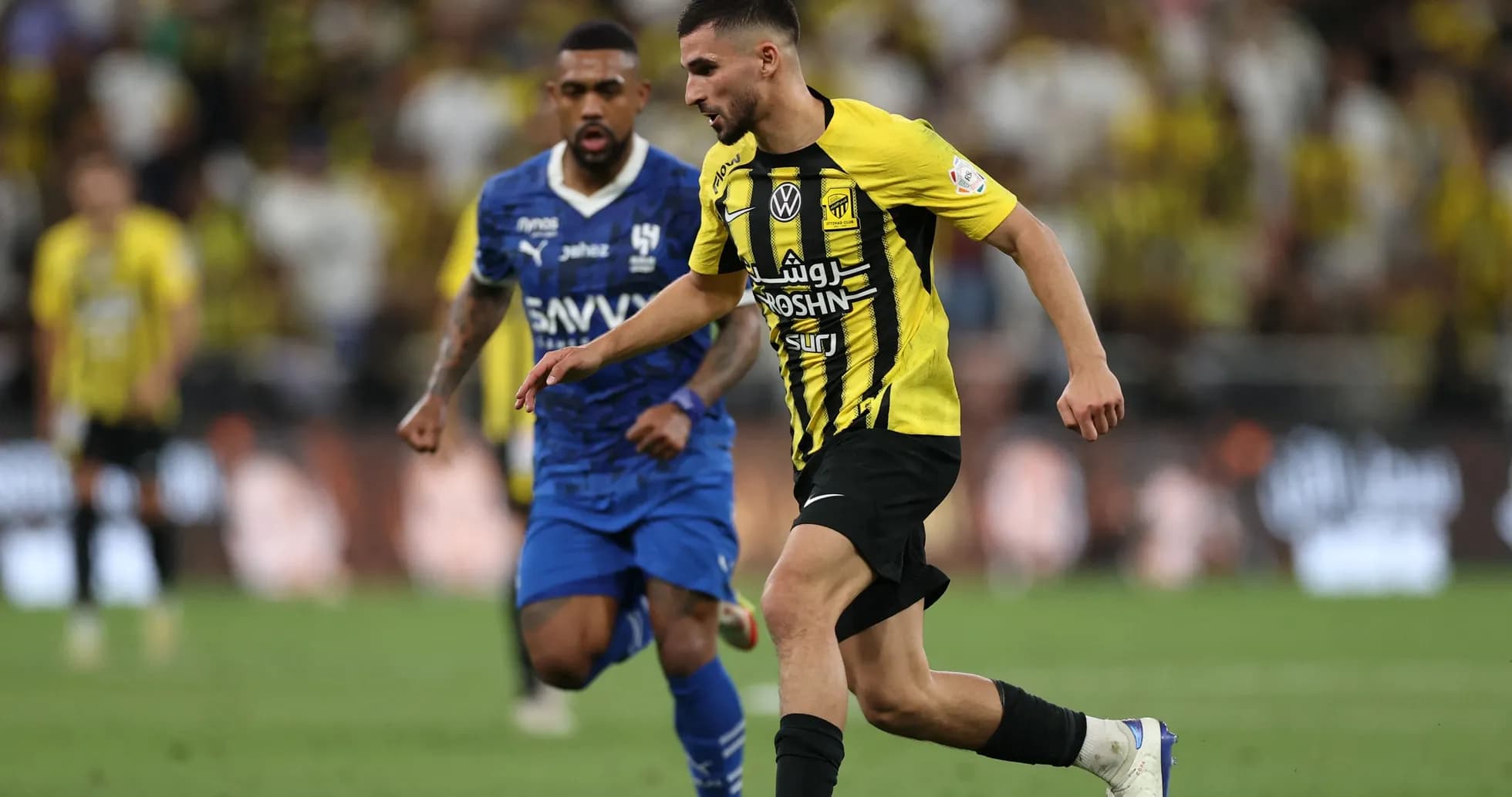 Player in yellow dribbling past opponent in blue