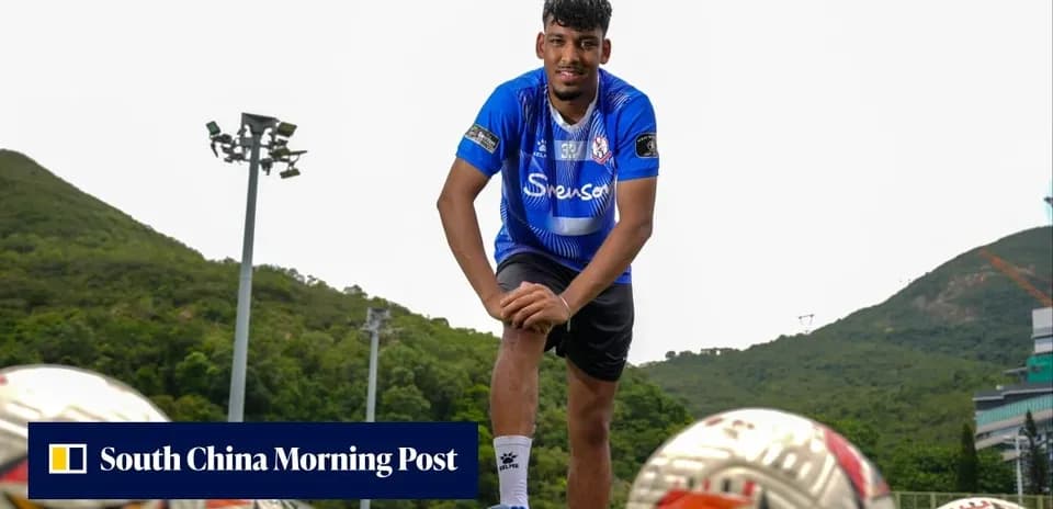 Player posing with footballs at training ground