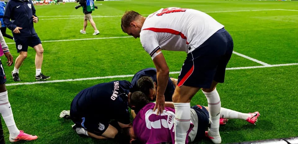 Team members assisting injured player on the field