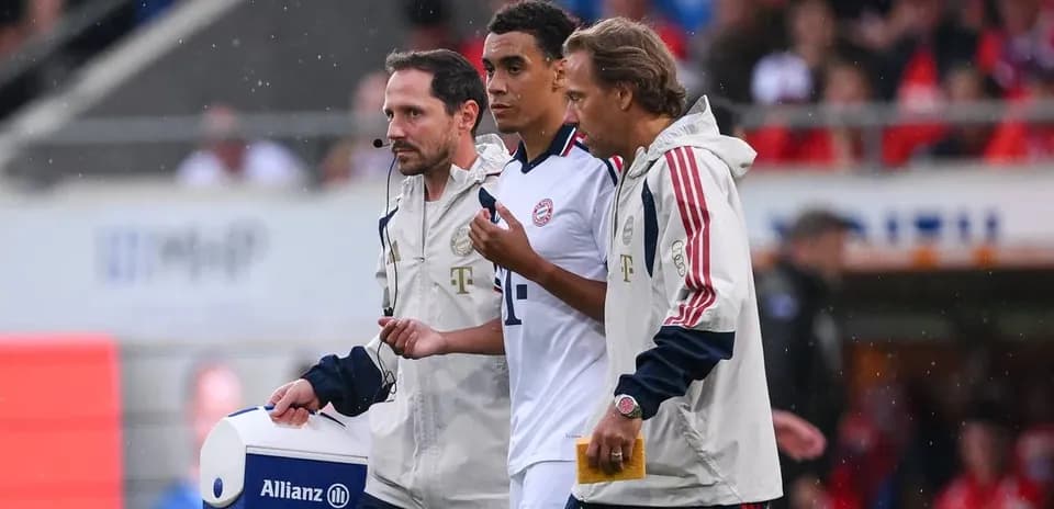 Player being assisted off field by staff members