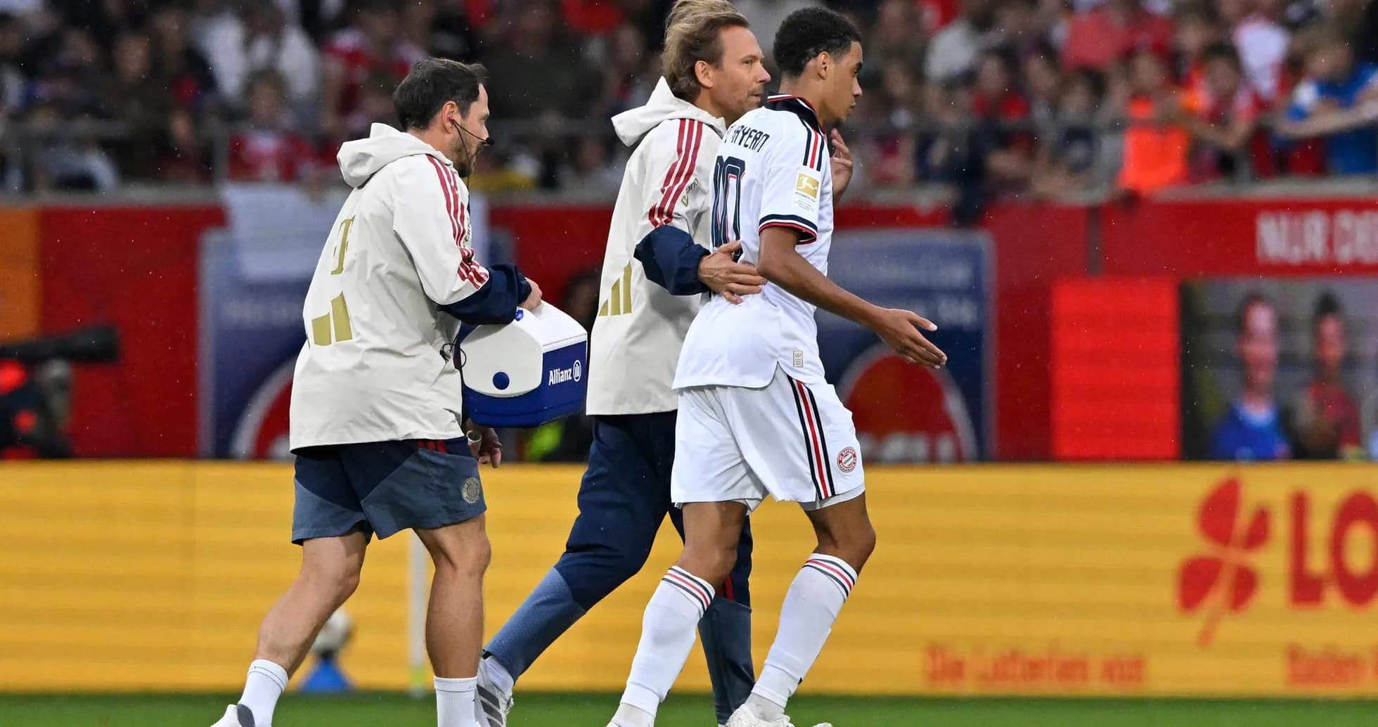 Player being assisted off the field by staff