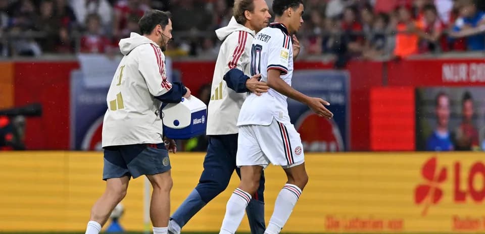 Player being assisted off the field by staff