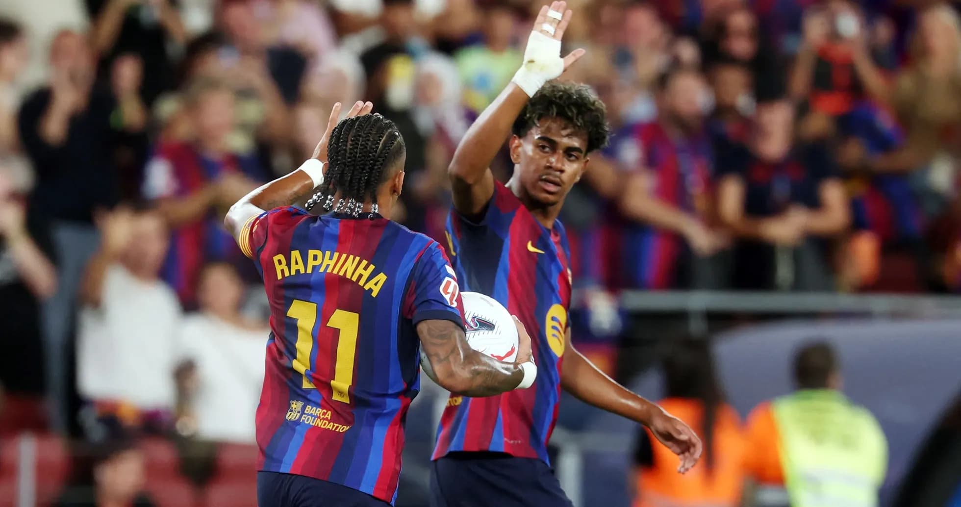 Two FC Barcelona players celebrating a goal together