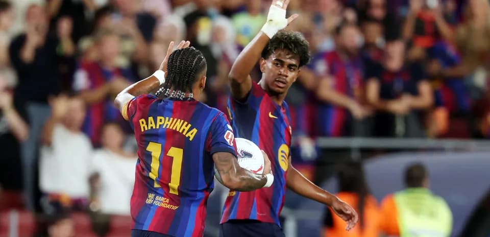 Two FC Barcelona players celebrating a goal together