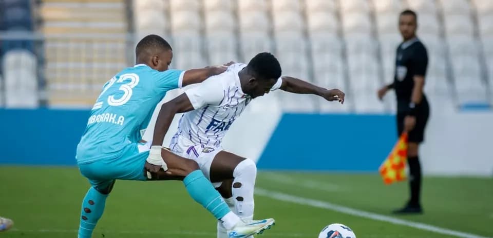 Goalkeeper challenges forward during U23 match