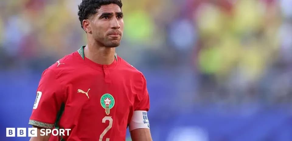 Moroccan player in red jersey walking on field