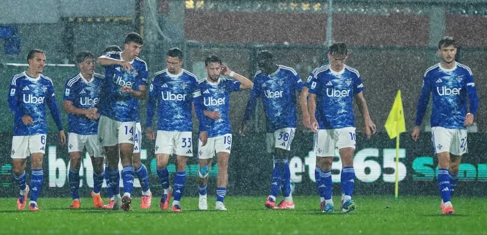 Como players walking on the pitch in rain