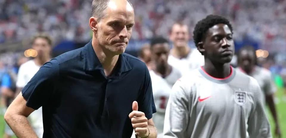 Coach and player walking off the pitch post-match