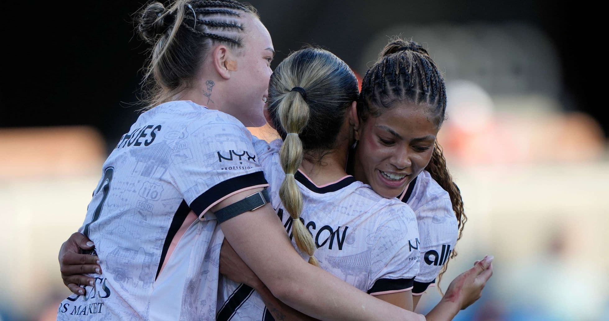 Players celebrating a goal during NWSL match