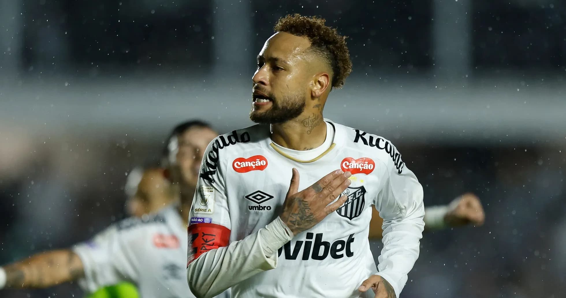 Player celebrating a goal in rainy match