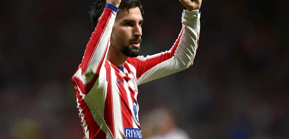 Player celebrating with raised arms in team jersey