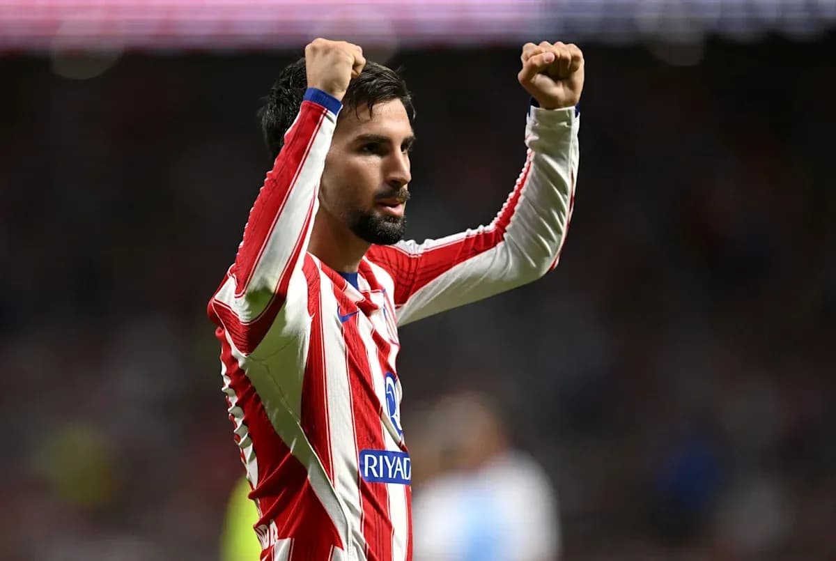 Player celebrating with raised arms in team jersey