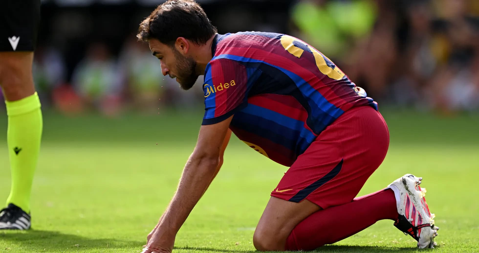 Player kneeling on pitch during match action