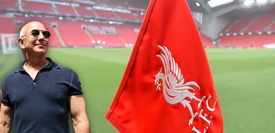 Person standing near Liverpool FC flag at stadium