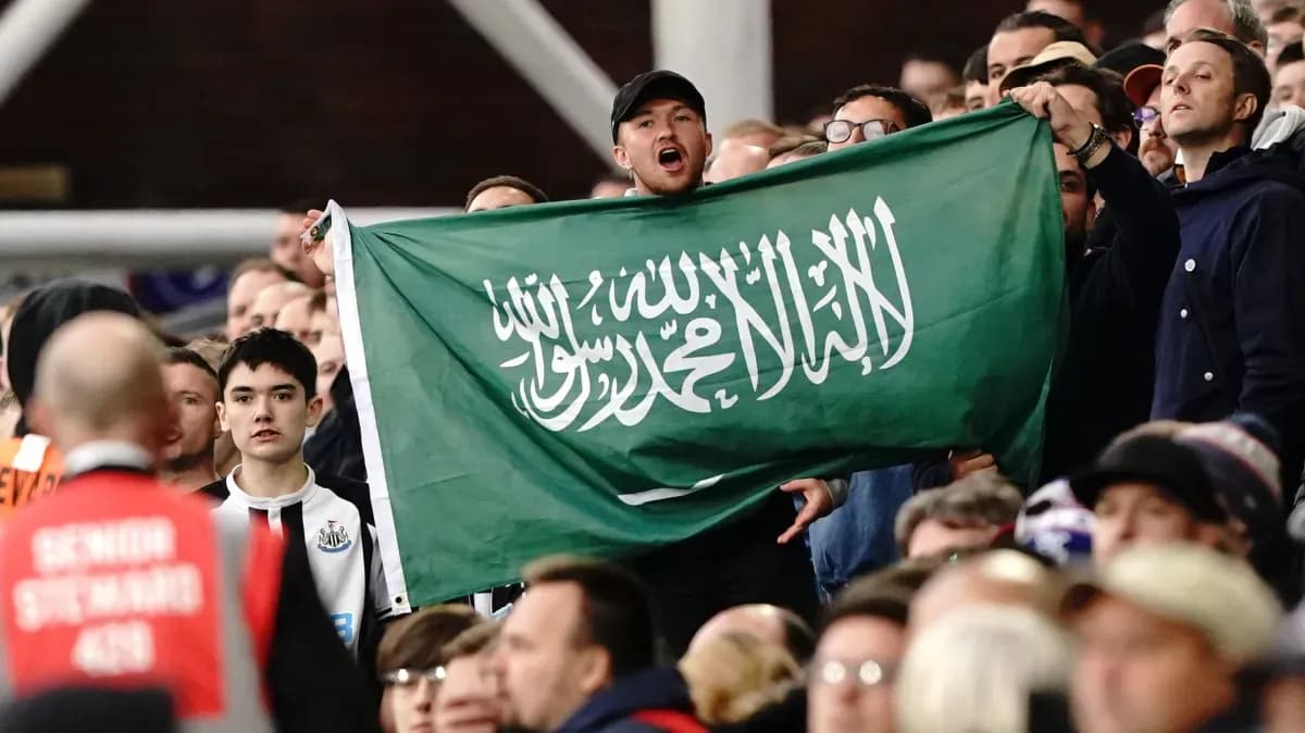 Fans holding Saudi Arabian flag in the stands