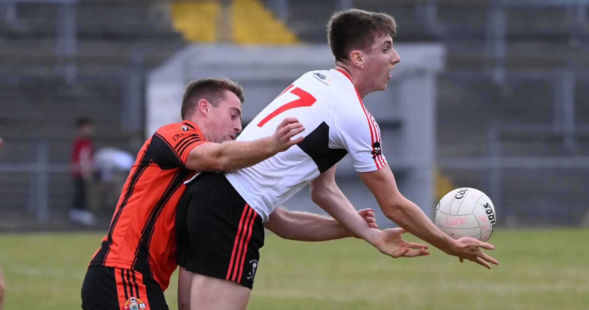 Player catching the ball while being tackled by opponent