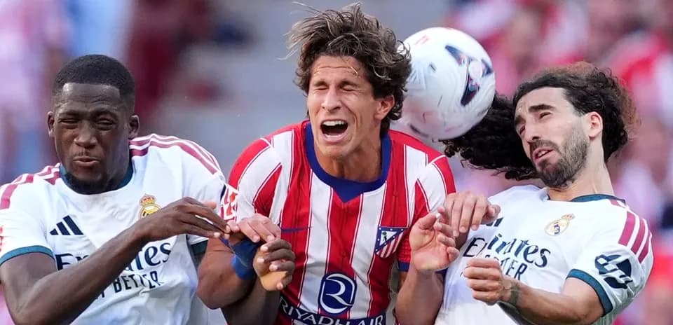 Players from Atlético Madrid and Real Madrid contesting for the ball
