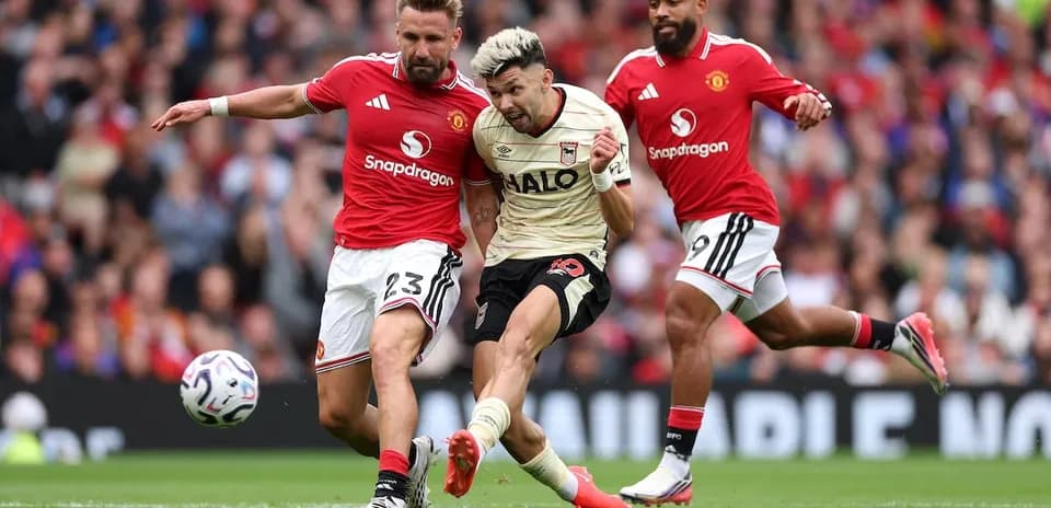 Manchester United players challenging Ipswich player