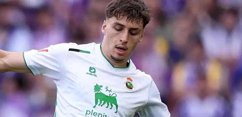 Player in white kit dribbling the ball during match