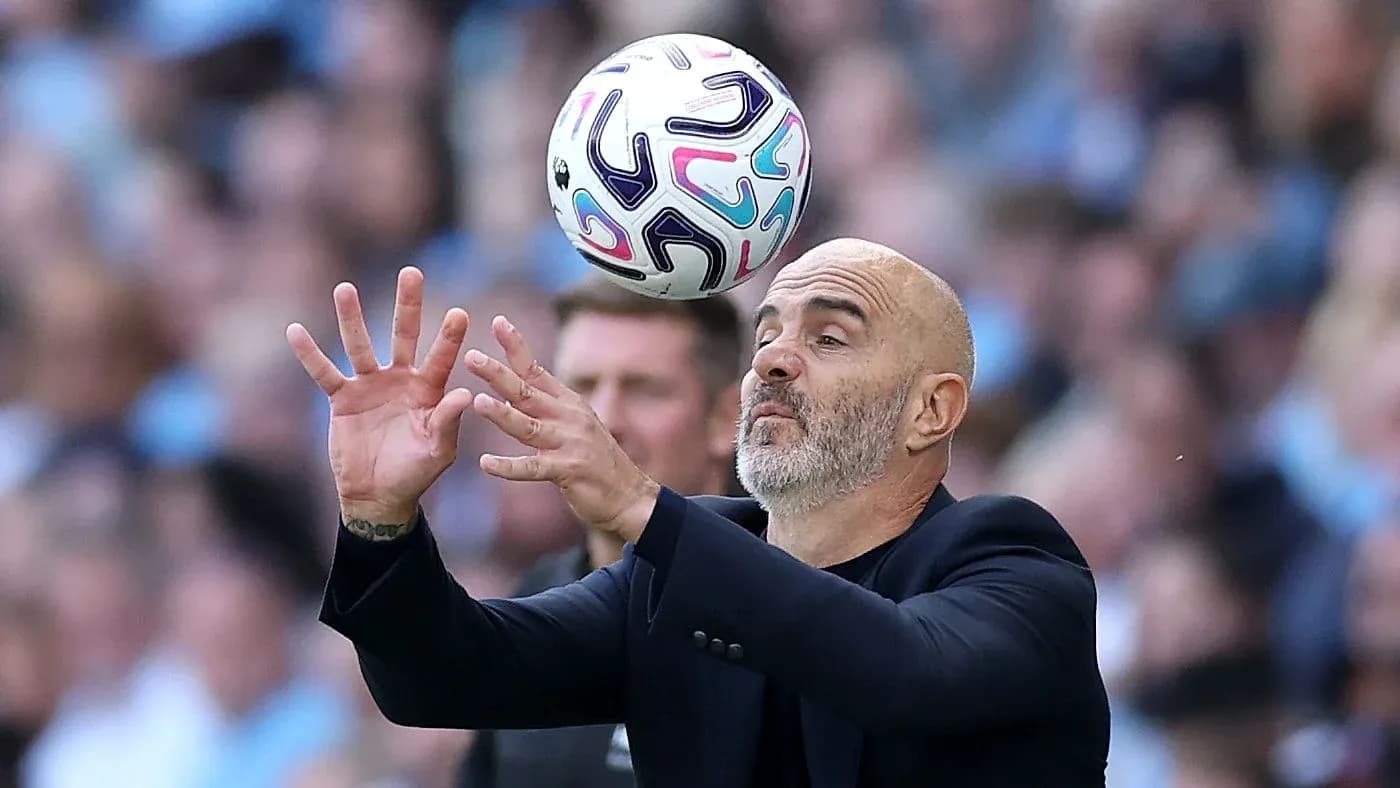 Coach attempting to catch a soccer ball during match