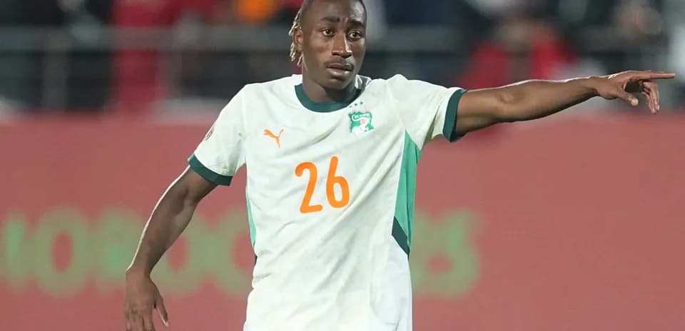 Player in Ivory Coast jersey directing teammates during match