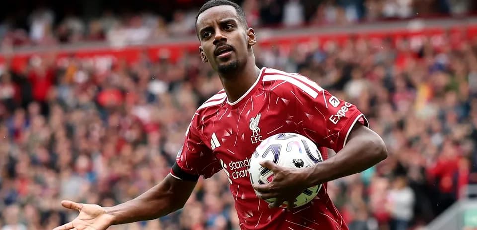 Player in Liverpool kit holding ball on pitch