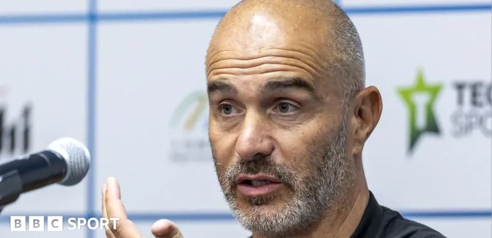 Coach speaking at press conference with microphone