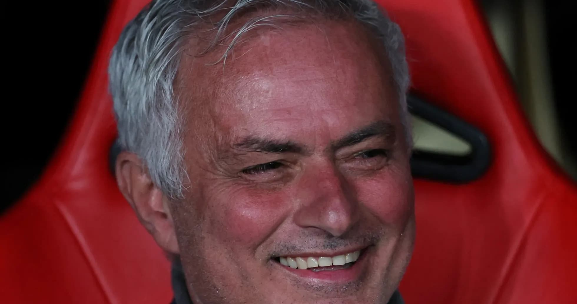 Coach sitting on bench with a smile