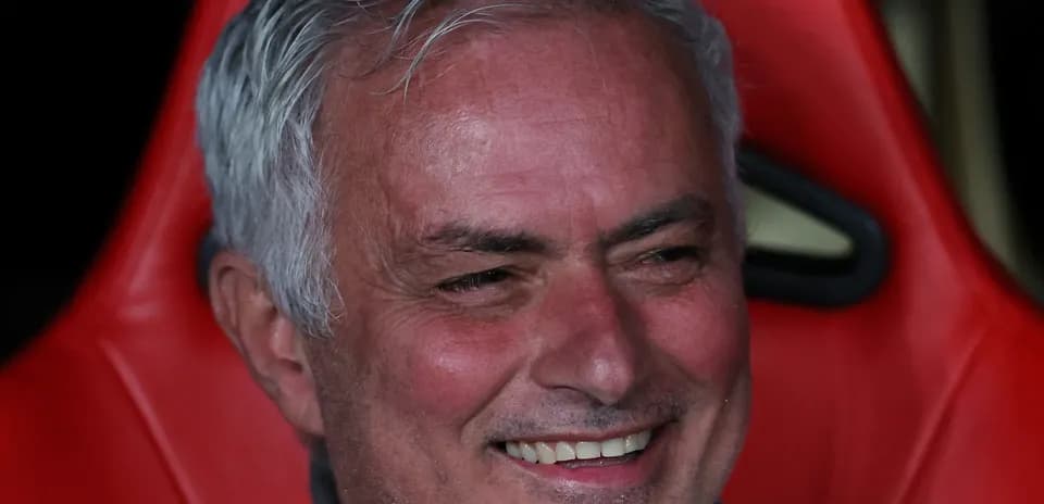 Coach sitting on bench with a smile