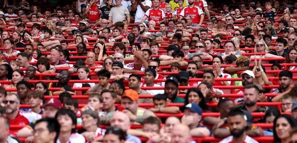 Crowd of fans wearing Arsenal jerseys in stadium