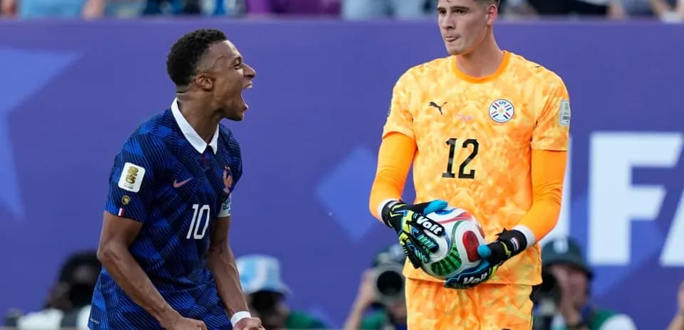 French player celebrating near Paraguayan goalkeeper