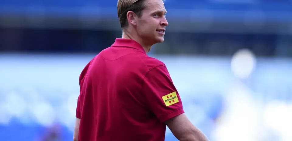 Man in red polo shirt on football pitch