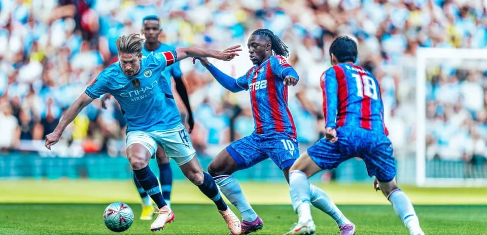 Manchester City player dribbling past Crystal Palace defenders