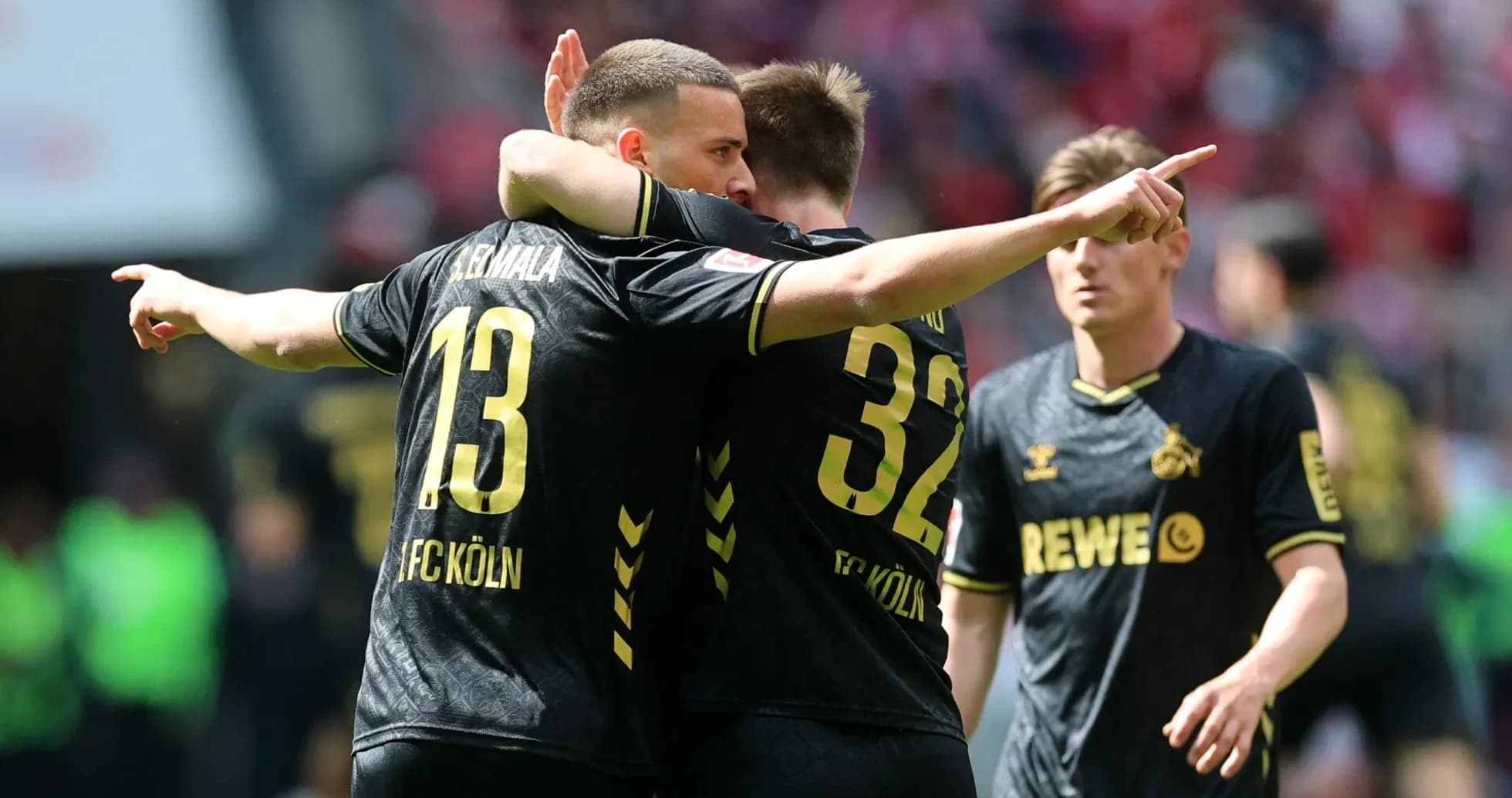 Two FC Köln players celebrating a goal on field